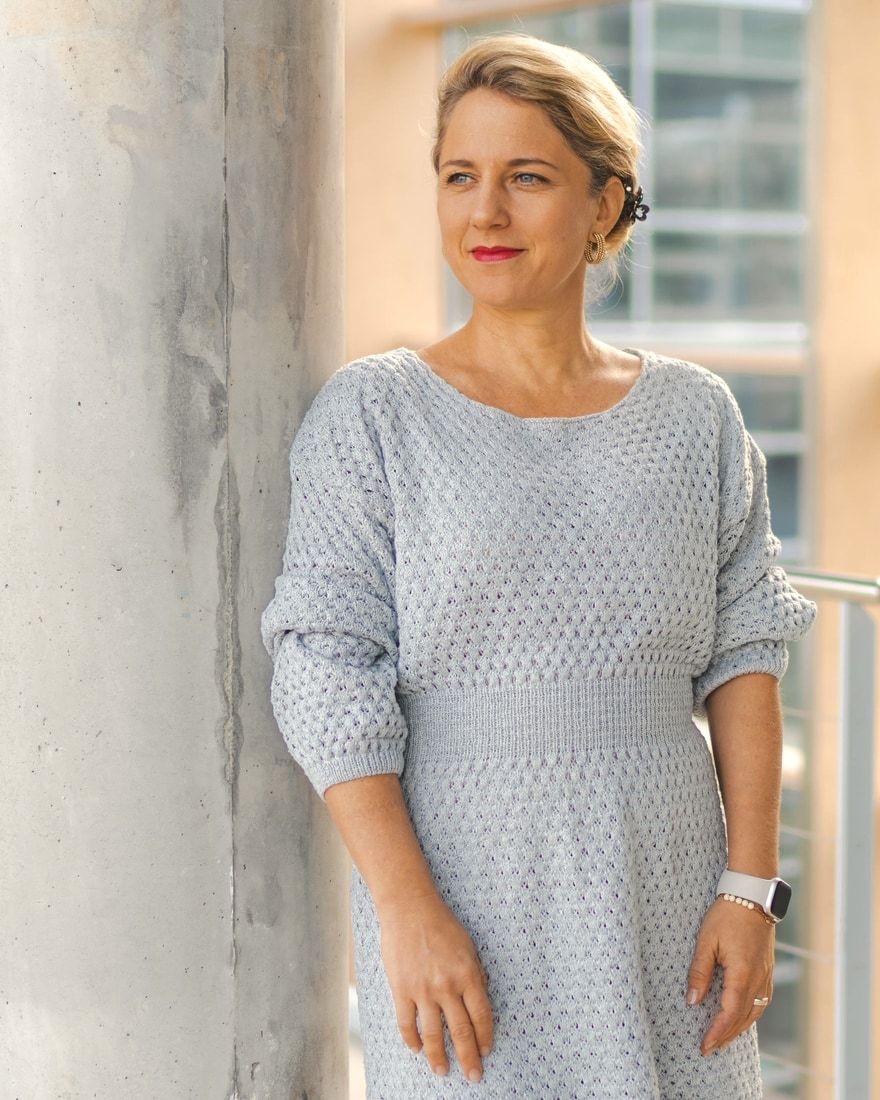 Gertrud Ledar, an eine Betonsäule gelehnt, blickt zur Seite